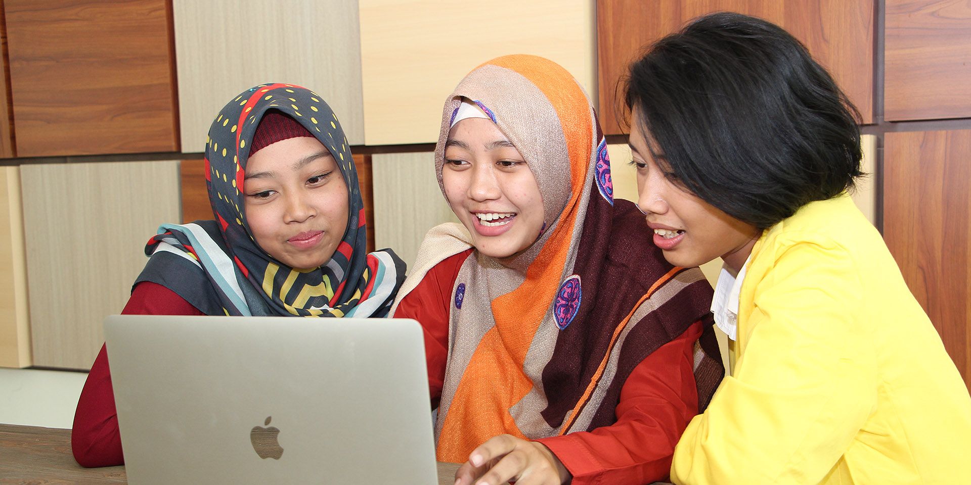 Three girls study on the computer.