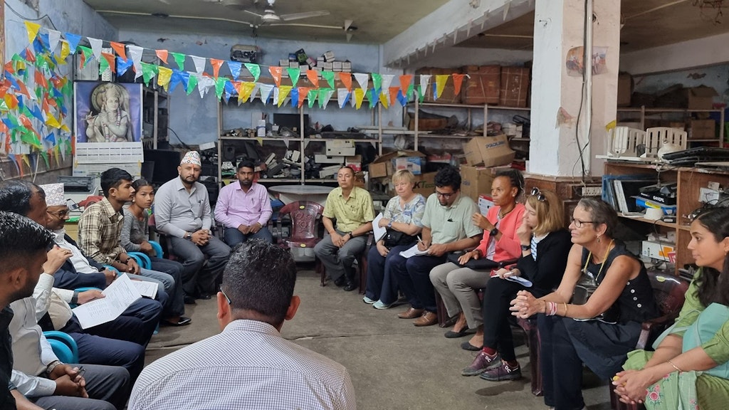 DEZA-Direktorin Patricia Danzi beim Besuch eines IT-Ausbildungszentrums in Nepal. Die Gesprächsteilnehmer sitzen in einem Kreis. Darunter auch zwei Schülerinnen und Schüler.