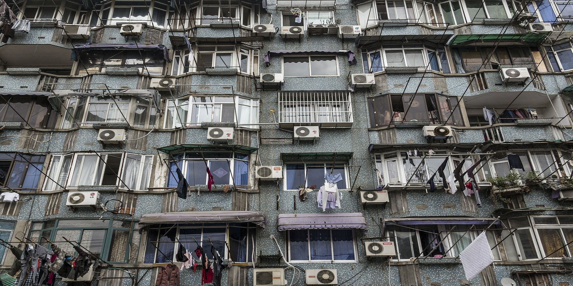 Façade d’un immeuble sur laquelle sont installés une multitude de vieux appareils de climatisation.