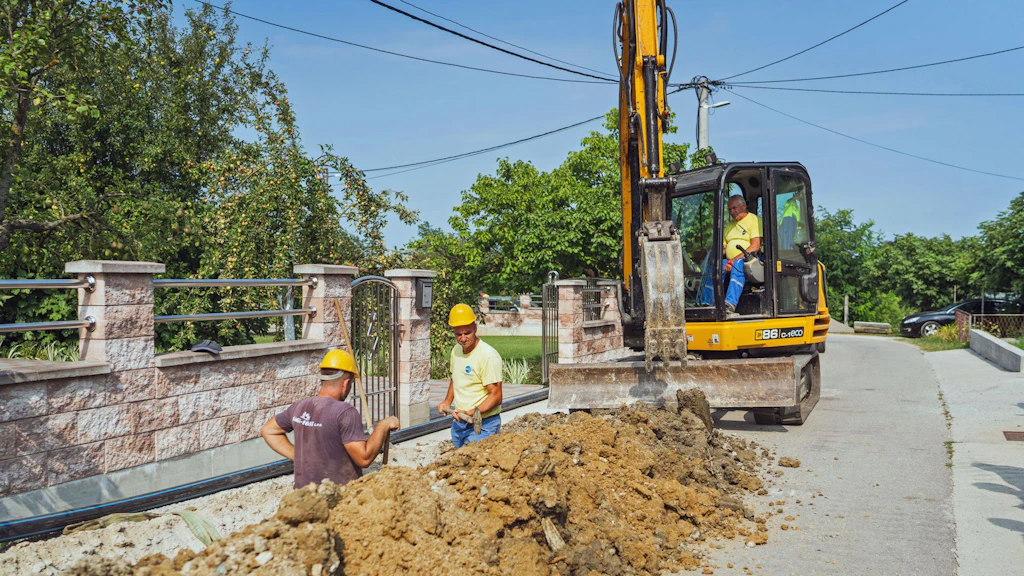 Bauarbeiter verlegen neue Wasserrohre in einem offenen Graben in einem Wohnquartier in Prijedor, Bosnien und Herzegowina.