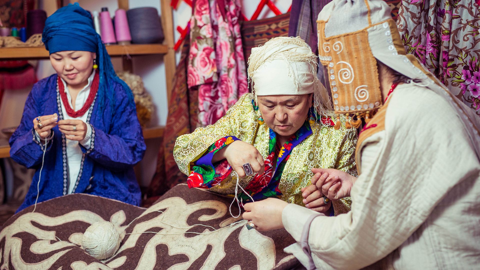 Drei Frauen in Kirgisistan arbeiten in der traditionellen Textilindustrie.