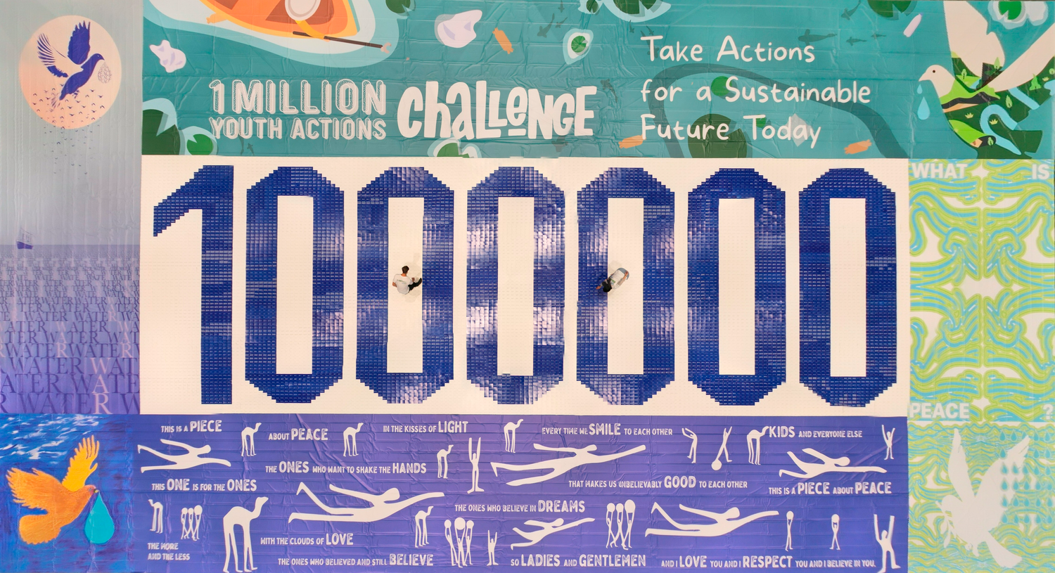 Von einem hohen Aussichtspunkt aus sieht man ein buntes Mosaik. Es gibt Zeichnungen von Vögeln und abstrakte Muster. In der Mitte erscheint die Zahl '1 Million' in Blau.