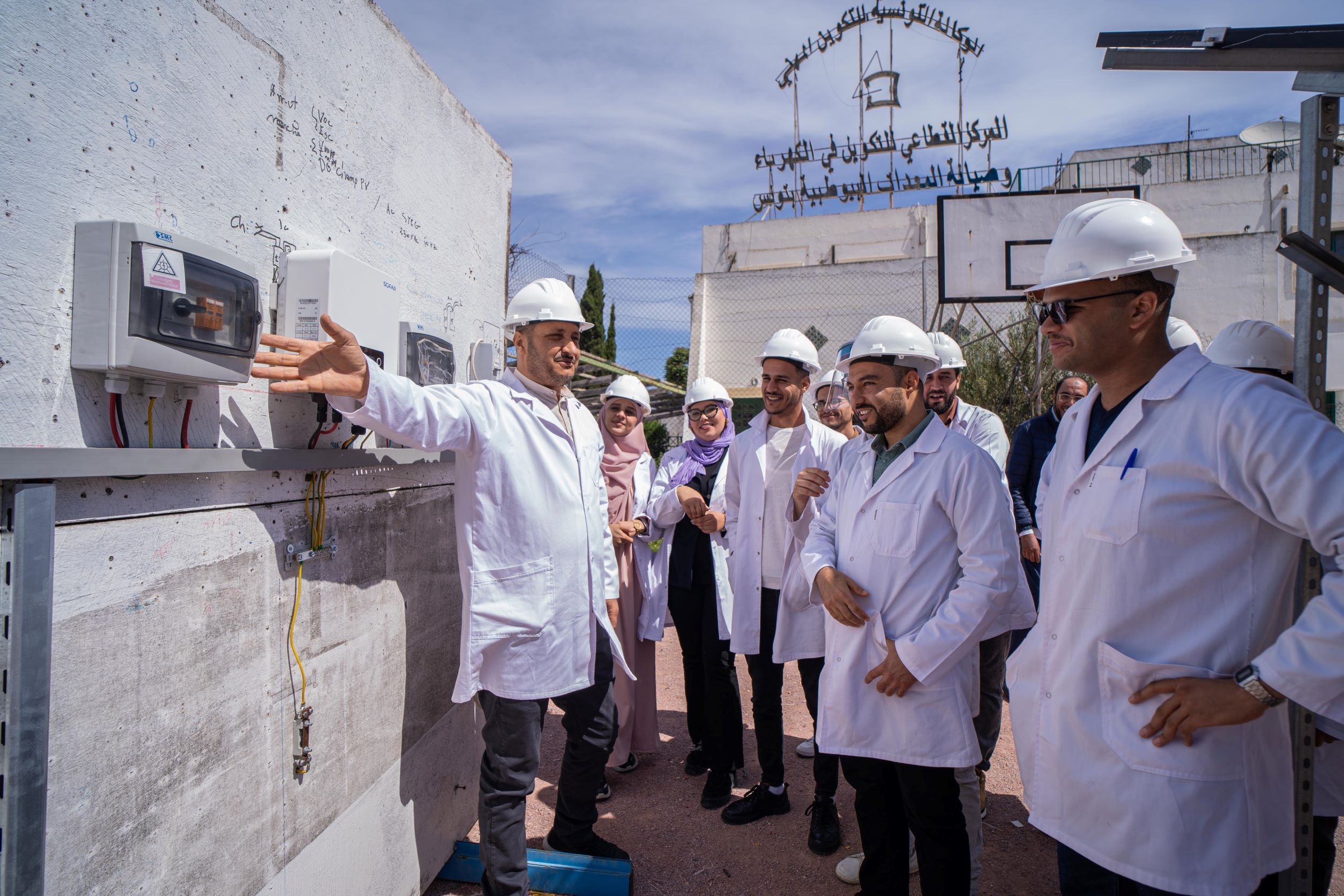 Eine Gruppe von Frauen und Männer stehen draussen und hören dem Ausbildner zu.