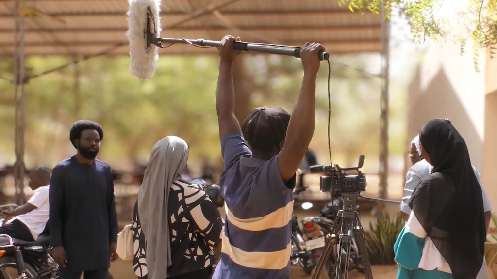 A film crew with cameras and microphones is in the middle of shooting a film. 