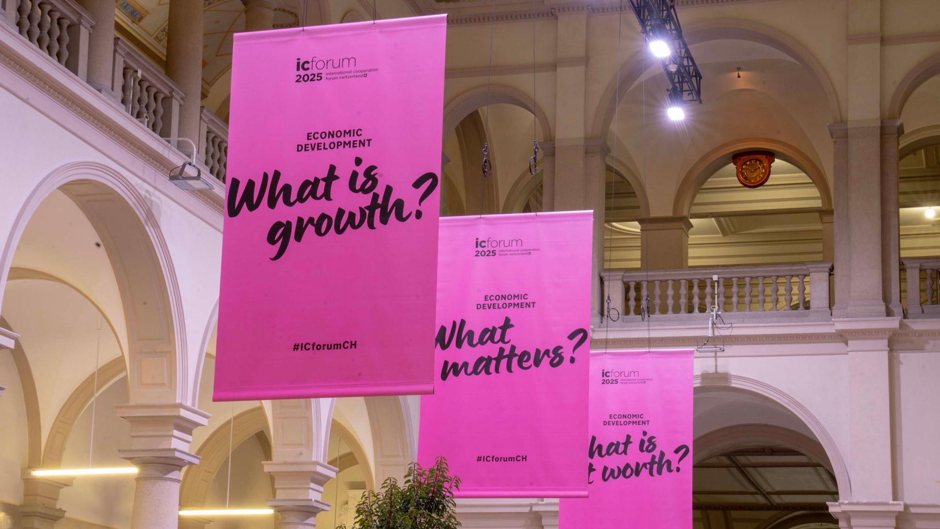 Pink signs displaying the various slogans of the IC Forum: ‘What is growth?’, ‘What matters?’ and ‘What is worth?’.