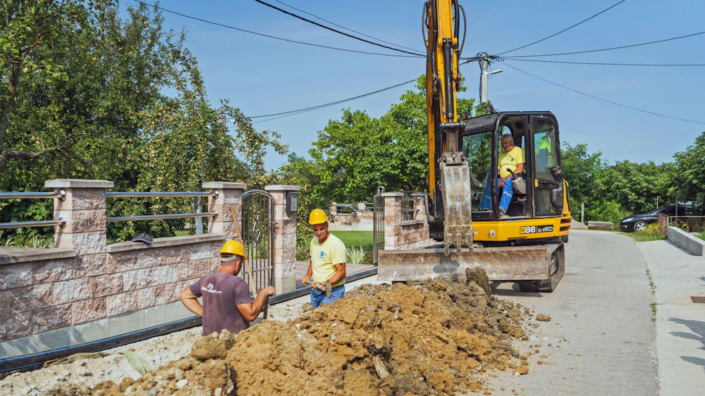 Construction workers lay new water pipes in an open trench in a residential neighbourhood in Prijedor, Bosnia and Herzegovina.