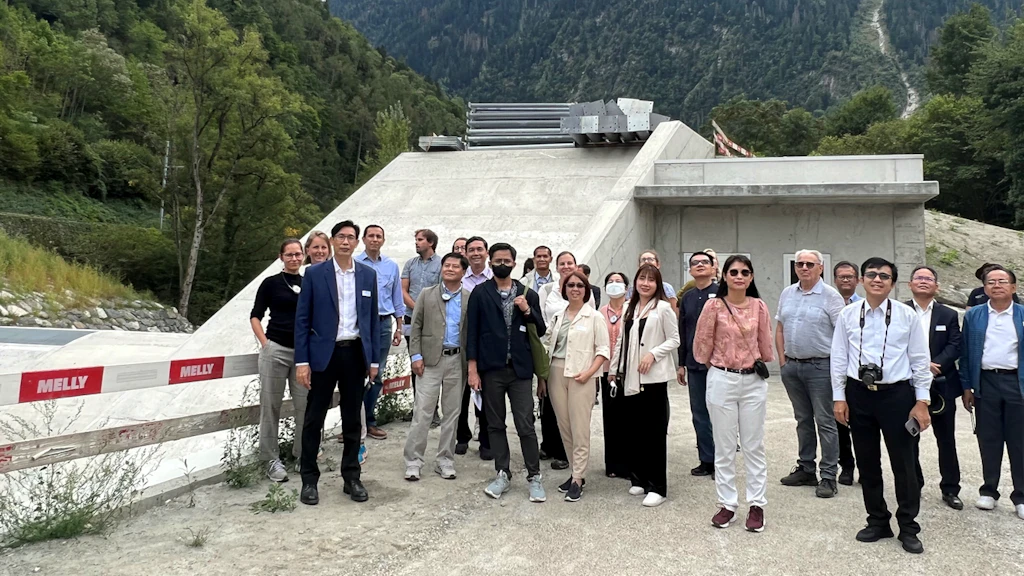 The two Asian delegations posing in front of a dam in Martigny.