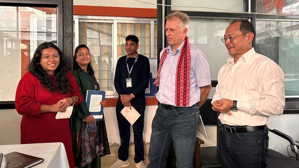 Arno Wicki is standing in a room surrounded by employees of the Suryodaya municipal administration. The mayor is standing to his right.