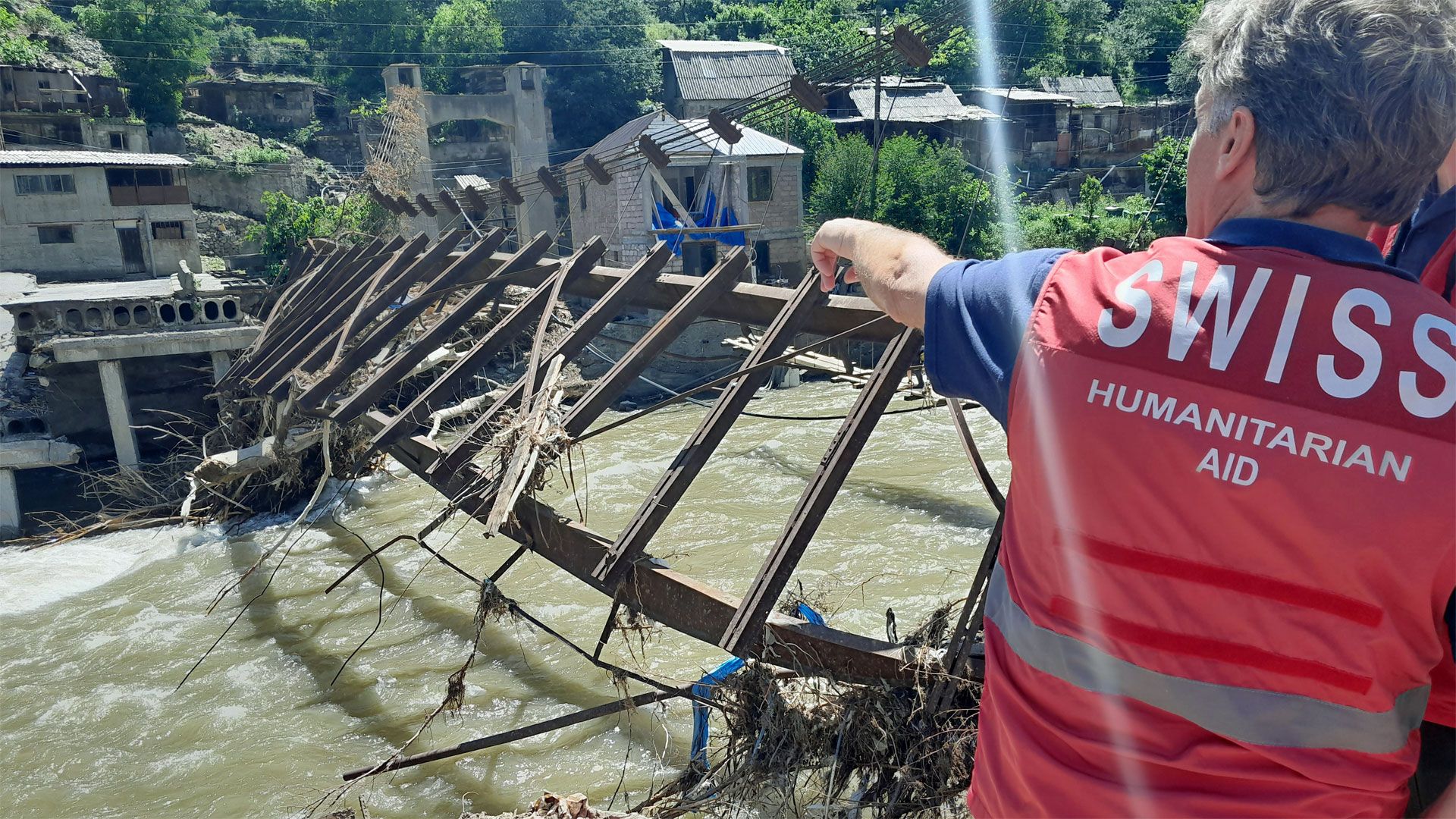 Swiss specialists standing in front of a collapsed bridge.