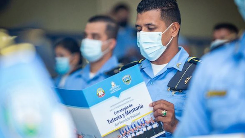A Honduran policeman studies a brochure.