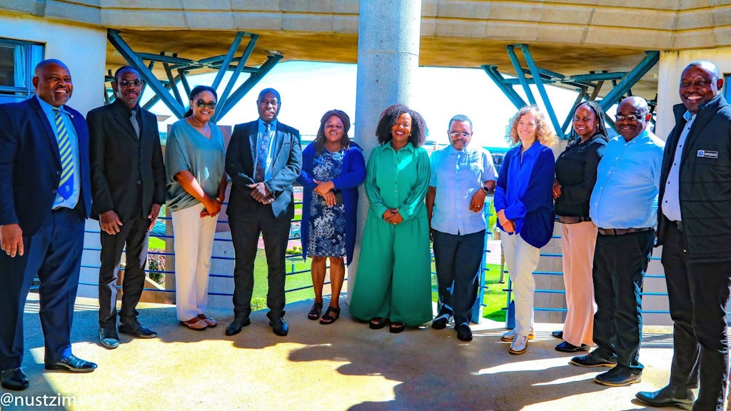 The SDC team stands in a semicircle on a balcony and looks into the camera.