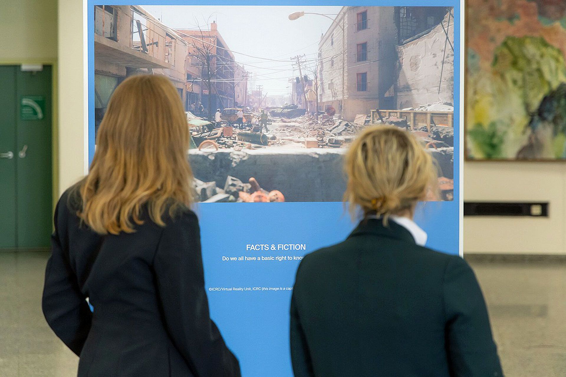 Two women at the Vienna exhibition viewing the virtual artwork 'ICRC / Virtual Reality Unit, ICRC'.