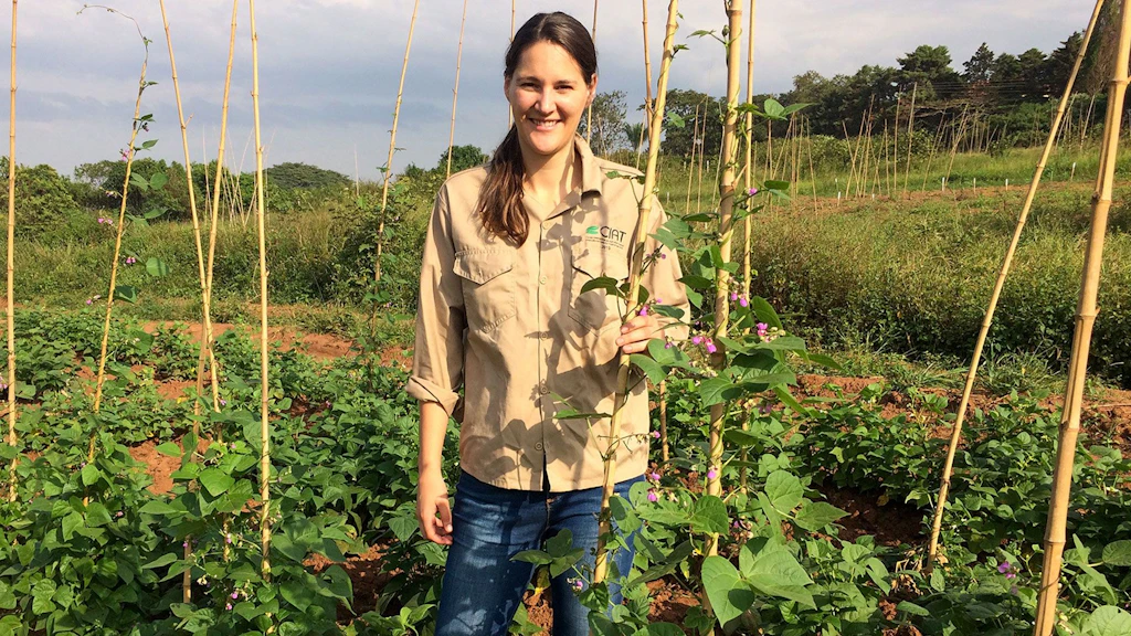 Dr Michelle Nay standing in a bean field in Colombia.