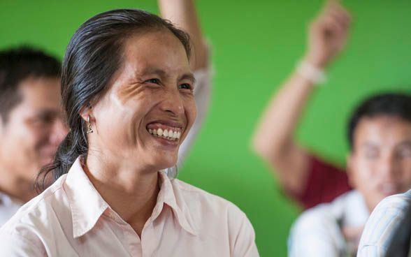 A woman smiles broadly during a prevention course run by the SDC.