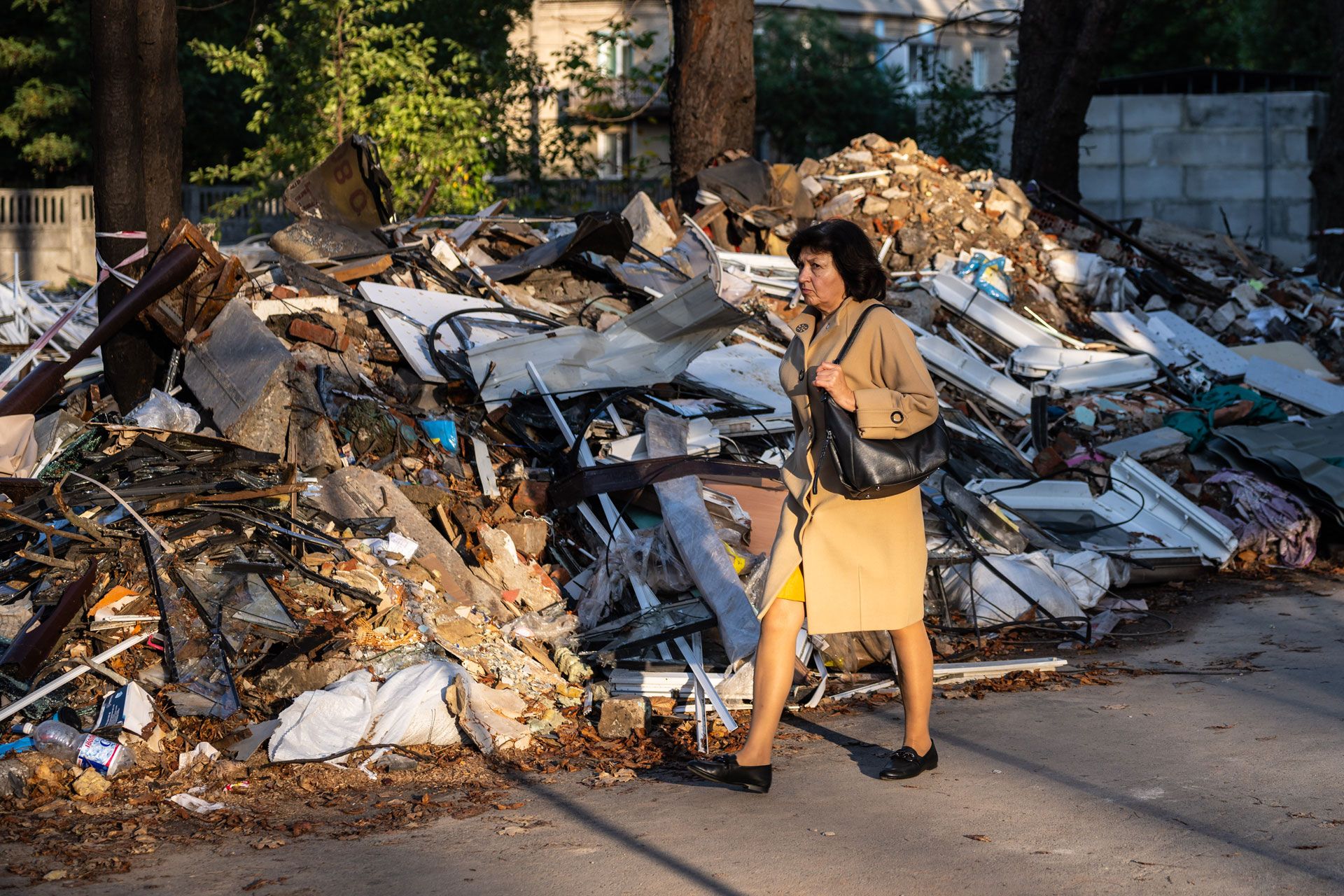 A woman walks past debris