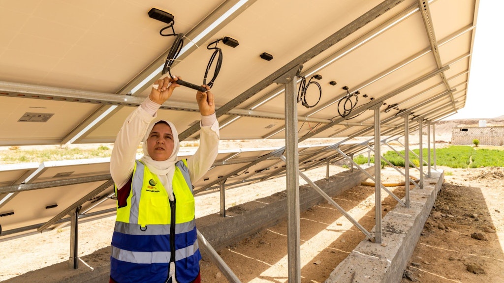 A female entrepreneur checks the wiring of a solar panel in Upper Egypt. 