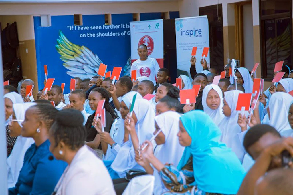 Parmi le public, des personnes lèvent une carte rouge ou verte à Tanga, en Tanzanie.