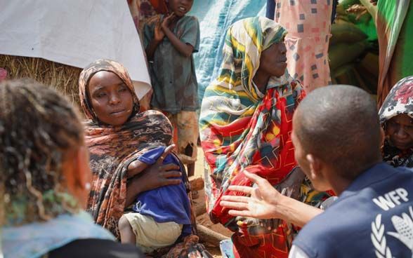 Le personnel humanitaire, avec Patricia Danzi, s’adresse à des femmes en tenue traditionnelle au Tchad.