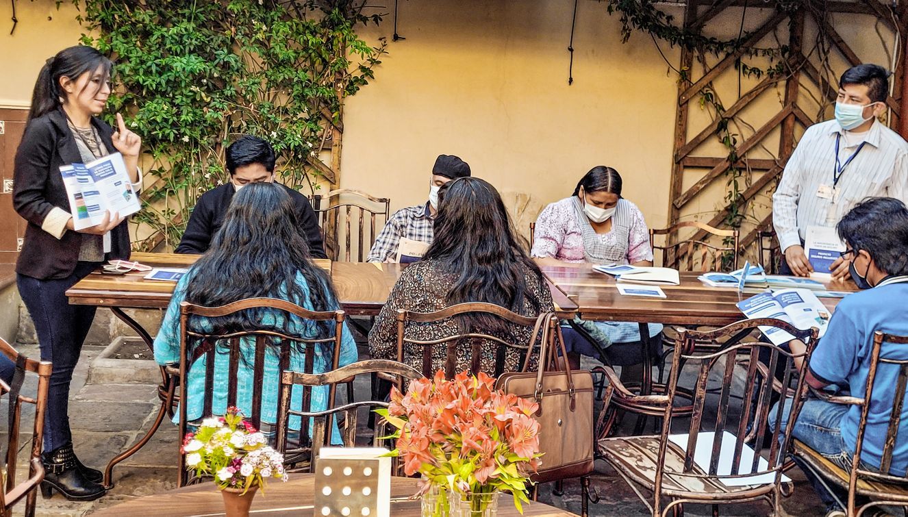 Lors d’un atelier, une spécialiste en assurance sensibilise les villageoises et villageois à des thèmes tels que les crédits, l’épargne ou la budgétisation.