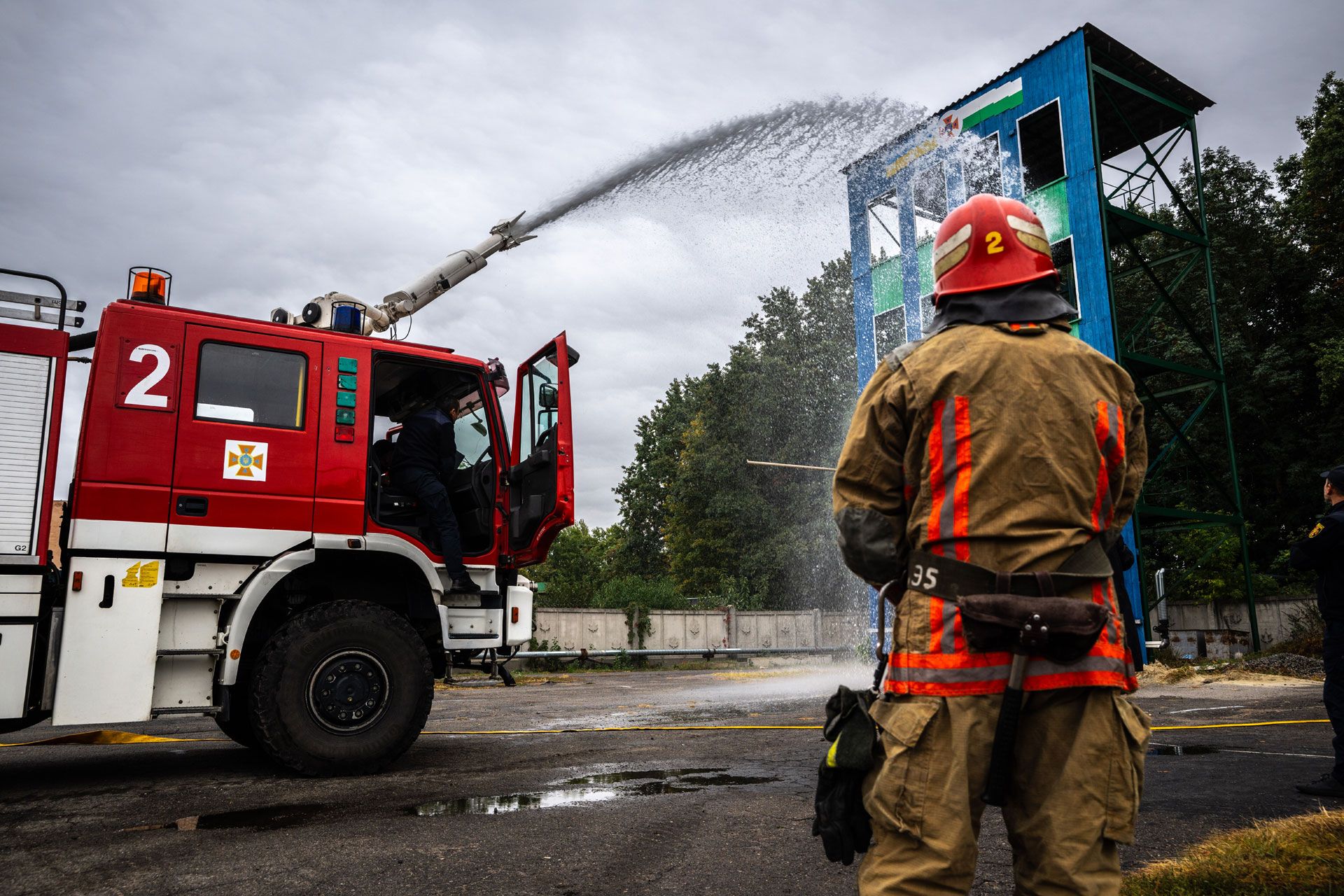 Des membres de la protection civile ukrainienne s'entraînent dans la lutte contre les incendies dans la ville de Poltava avec un véhicule d'extinction offert par la Suisse.