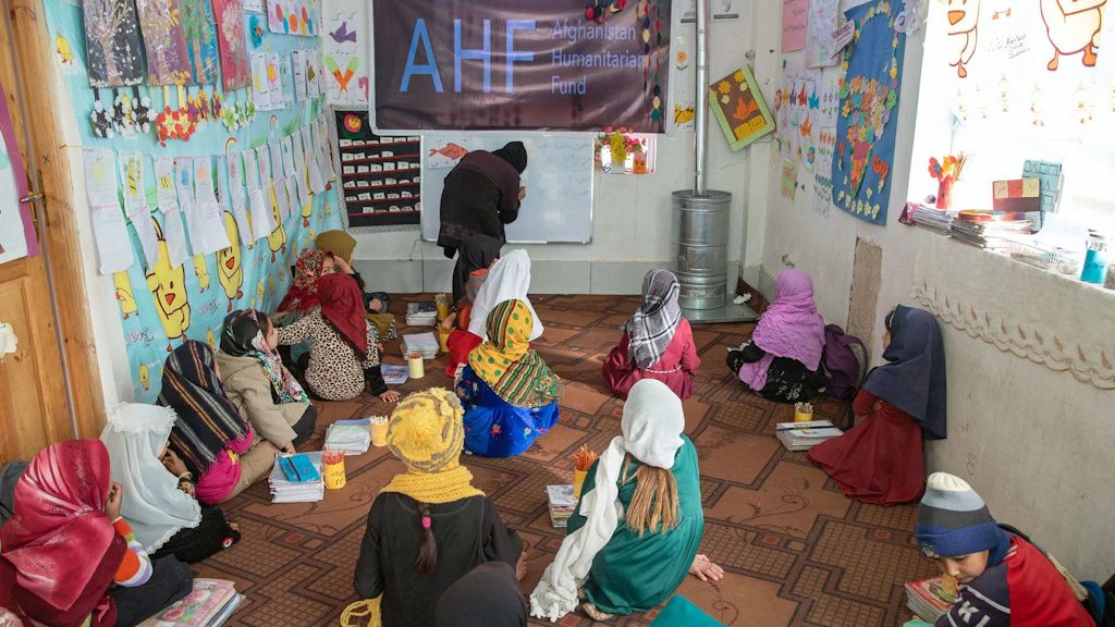 Des filles assises par terre dans une salle de classe.