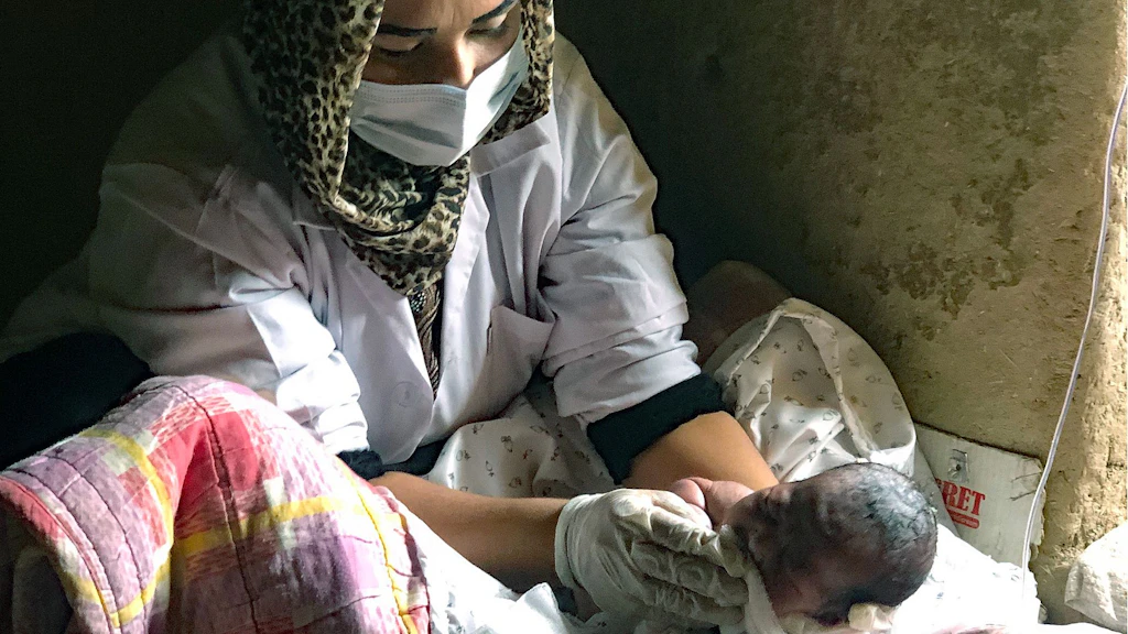 Une sage-femme assiste à la naissance d'un nouveau-né. 