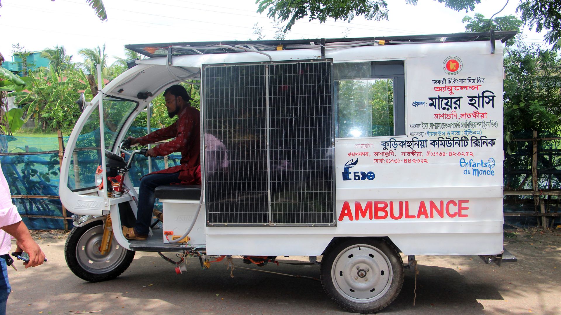 Un homme conduit un véhicule d’ambulance à trois roues, fonctionnant à l’énergie solaire et fabriqué localement.