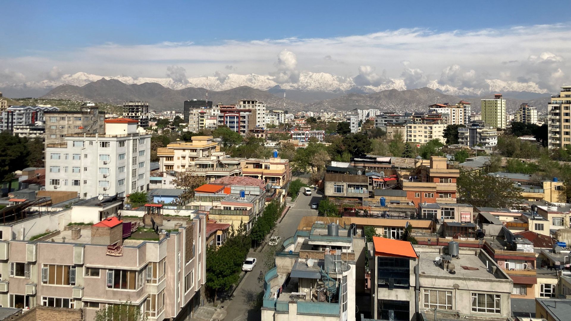 Vista dall’alto su Kabul, con cime innevate sullo sfondo.