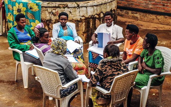 Lavoro di gruppo nell'ambito dell'approccio comunitario "We Heal Together" in Ruanda. Otto donne siedono in cerchio e parlano tra loro.