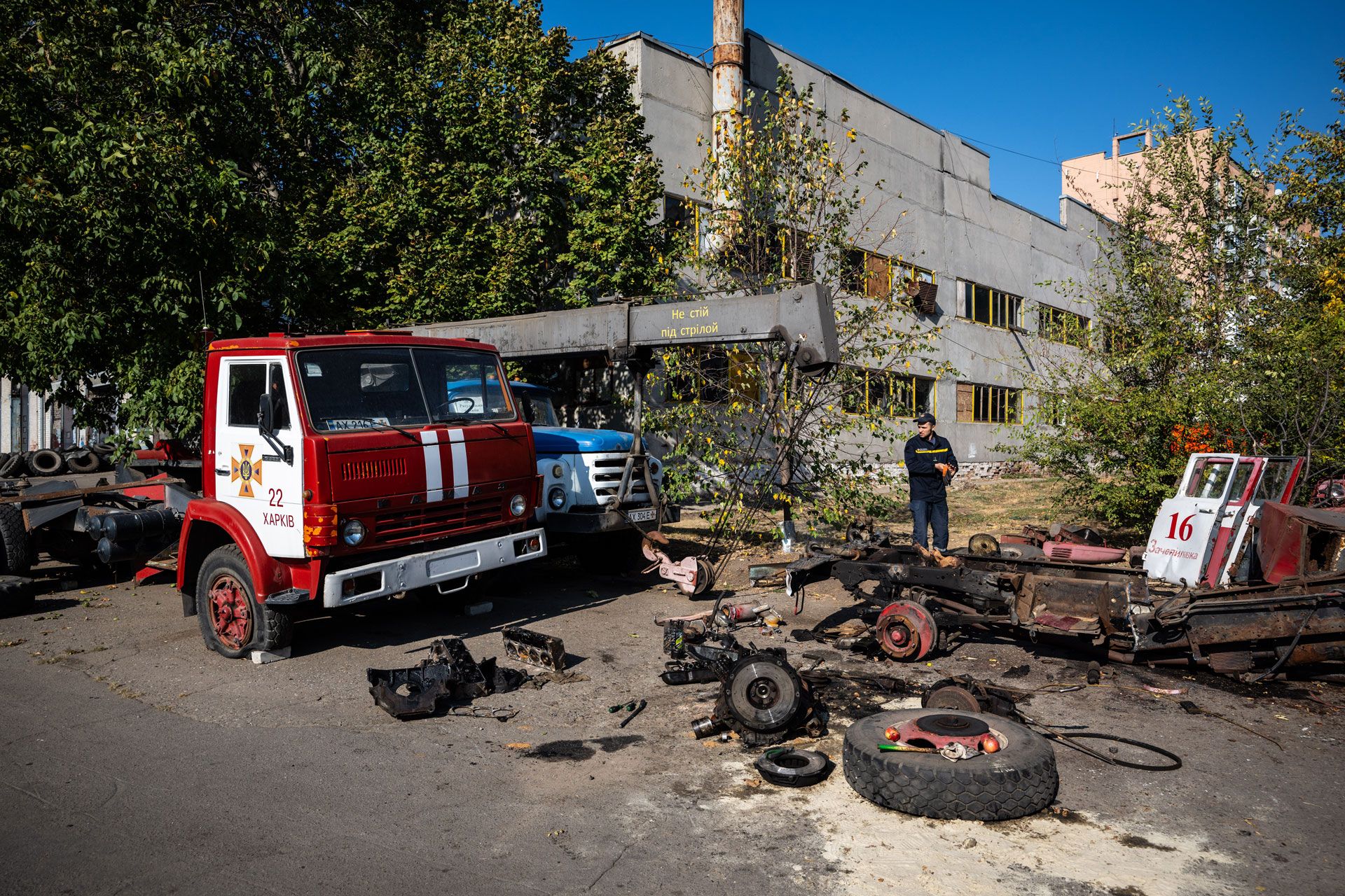 Un membro della squadra di protezione civile ucraina utilizza i pezzi di ricambio di un veicolo distrutto.