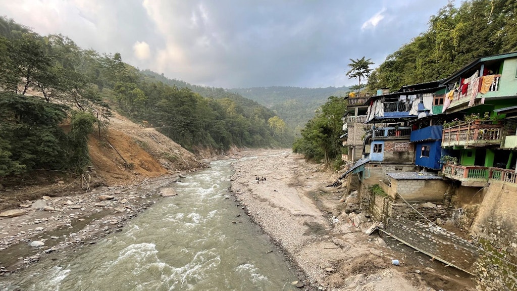 Le case si trovano sulla destra di una strada il cui lato sinistro è stato spazzato via. Ora lì scorre un fiume.