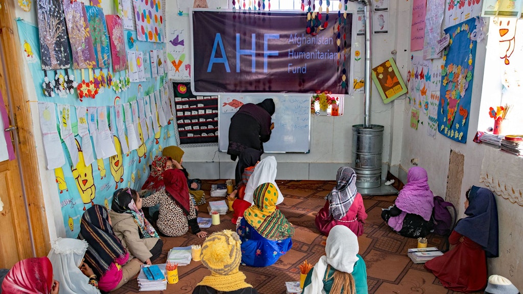 Bambini seduti sul pavimento in un'aula. 