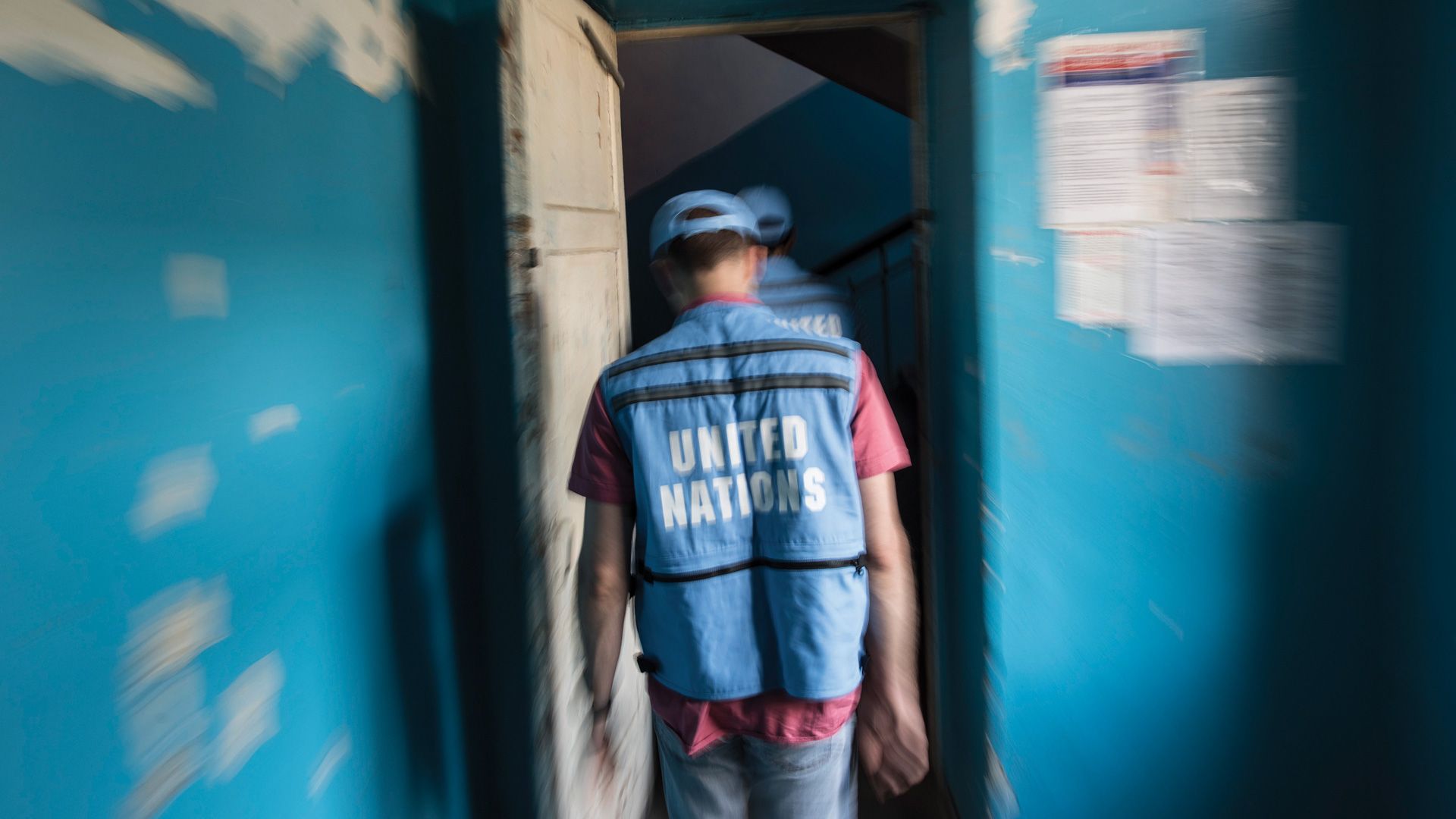 Alcuni membri dell’ONU con la veste blu del personale dell’Organizzazione mentre varcano una soglia.