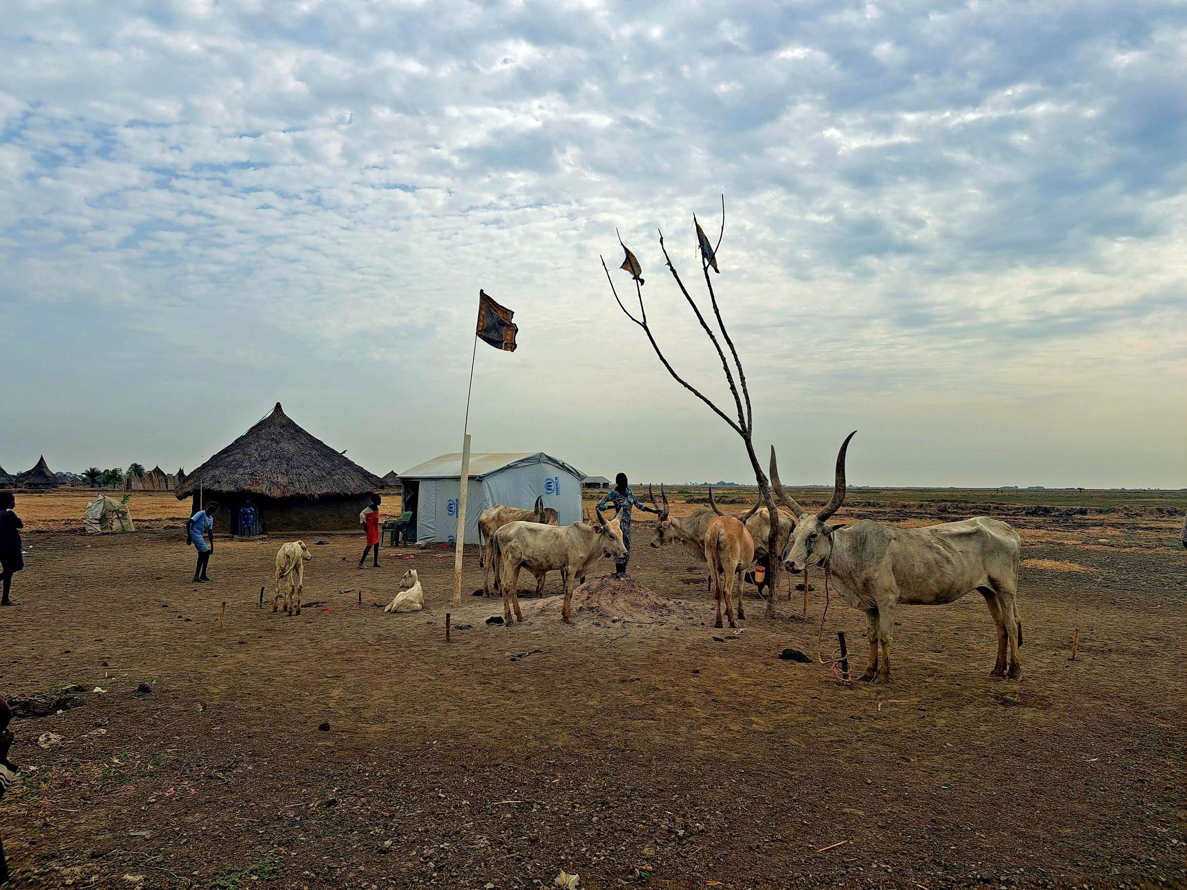 Un paesaggio con alcuni animali, una capanna e due uomini.