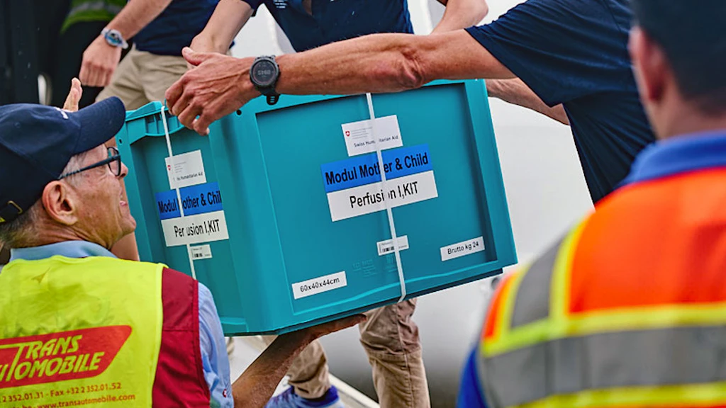 Un’esperta scarica dall’aereo una cassa contenente materiale medico. 